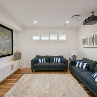 Home theater - contemporary enclosed medium tone wood floor and brown floor home theater idea in Sydney with white walls and a projector screen