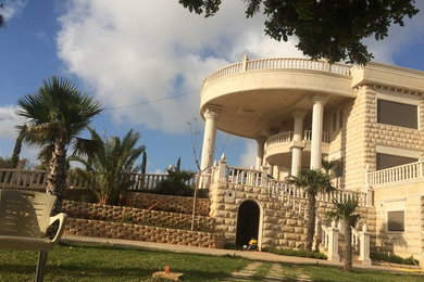 Huge white stone exterior home idea in Other with a shed roof