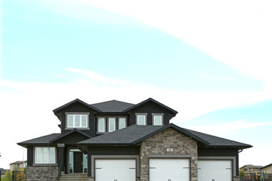 Inspiration for a black two-story stucco house exterior remodel in Other with a shingle roof