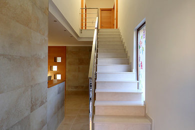 Ejemplo de escalera recta moderna grande con escalones con baldosas y contrahuellas con baldosas y/o azulejos