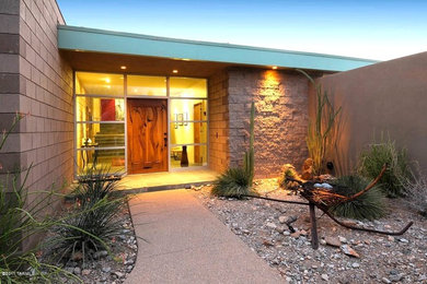 Example of a large minimalist ceramic tile entryway design in Phoenix with beige walls and a dark wood front door