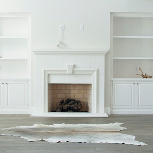 Diseño de salón para visitas abierto, mediterráneo, grande, con paredes blancas, suelo de madera en tonos medios, chimenea tradicional, marco de chimenea de ladrillo y pared multimedia