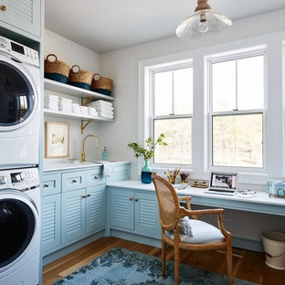 This is an example of a nautical l-shaped utility room in Perth with louvered cabinets, blue cabinets, medium hardwood flooring and brown floors.