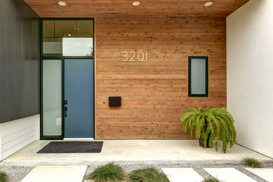 Entryway - large modern concrete floor entryway idea in Austin with multicolored walls and a blue front door