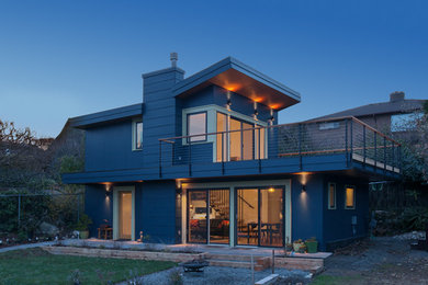Design ideas for a small modern two-storey blue house exterior in Seattle with a shed roof.