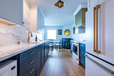 Example of a mid-sized transitional galley laminate floor and brown floor eat-in kitchen design in Seattle with an undermount sink, shaker cabinets, quartz countertops, white backsplash, quartz backsplash, white appliances, no island, white countertops and blue cabinets