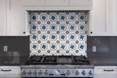 Traditional kitchen in Los Angeles with recessed-panel cabinets and cement tile splashback.
