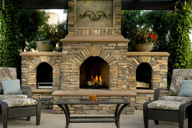 Example of a mid-sized transitional backyard concrete paver patio design in Orange County with a fire pit and a pergola