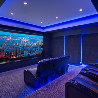 Idées déco pour une grande salle de cinéma moderne fermée avec un mur noir, moquette, un écran de projection et un sol violet.