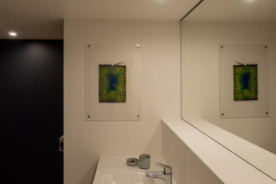 Aménagement d'une grande salle de bain principale contemporaine avec un placard à porte plane, des portes de placard blanches, un mur blanc, un lavabo intégré, un plan de toilette blanc, meuble simple vasque et meuble-lavabo suspendu.