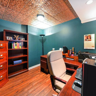 Imagen de sótano con puerta tradicional, pequeño, con paredes verdes, moqueta, chimenea tradicional y marco de chimenea de piedra