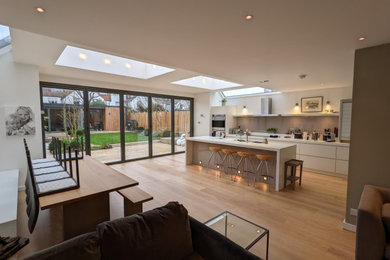 Cette photo montre une grande salle à manger ouverte sur le salon moderne avec un sol en bois brun.