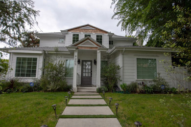 Example of a mid-sized white two-story wood house exterior design in Los Angeles with a hip roof and a tile roof