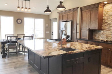 Inspiration for a large transitional porcelain tile, gray floor and vaulted ceiling open concept kitchen remodel in San Diego with an undermount sink, flat-panel cabinets, dark wood cabinets, quartz countertops, brown backsplash, stone tile backsplash, stainless steel appliances, an island and gray countertops