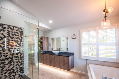 Example of a large trendy master brown tile and mosaic tile porcelain tile, brown floor and single-sink bathroom design in DC Metro with flat-panel cabinets, medium tone wood cabinets, a two-piece toilet, gray walls, a vessel sink, granite countertops, black countertops and a floating vanity
