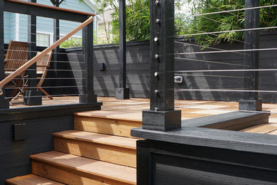 Example of a mid-sized minimalist backyard deck design in Houston with a roof extension