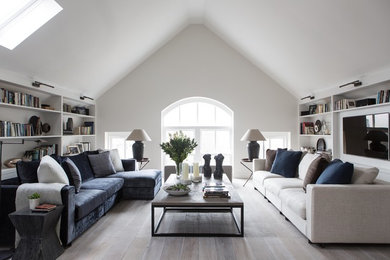 Photo of a large contemporary open plan living room in London with white walls, painted wood flooring, a wall mounted tv and grey floors.