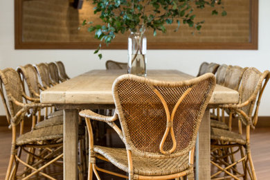 Foto di una sala da pranzo aperta verso il soggiorno country con pareti bianche, parquet chiaro e pavimento marrone