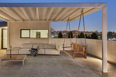 Example of a large tuscan privacy and mixed material railing balcony design in Los Angeles with a pergola