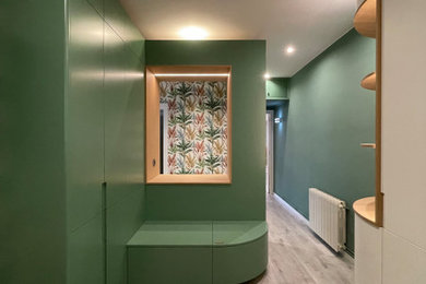 Ejemplo de hall minimalista grande con paredes verdes, suelo de madera clara, suelo gris y papel pintado
