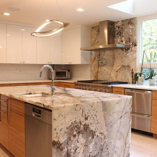 Modern inredning av ett stort beige beige kök, med en undermonterad diskho, släta luckor, orange skåp, granitbänkskiva, vitt stänkskydd, rostfria vitvaror, klinkergolv i porslin, en köksö och vitt golv