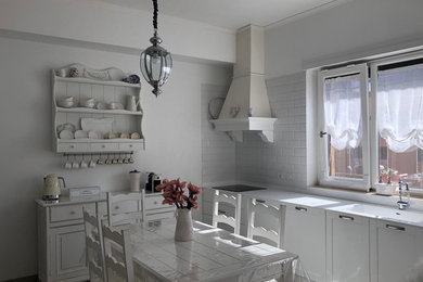 Immagine di una cucina shabby-chic style con lavello integrato, ante con riquadro incassato, ante bianche, paraspruzzi bianco, elettrodomestici in acciaio inossidabile, pavimento in marmo, nessuna isola, pavimento grigio e top bianco