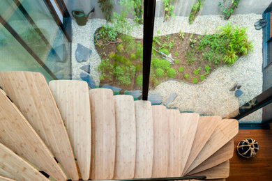 Foto de escalera en U actual grande sin contrahuella con escalones de madera, barandilla de metal y madera