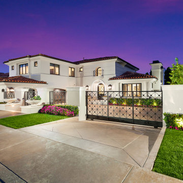 Gated Mediterranean Estate at Twilight with Custom Iron Driveway Gates – Newport