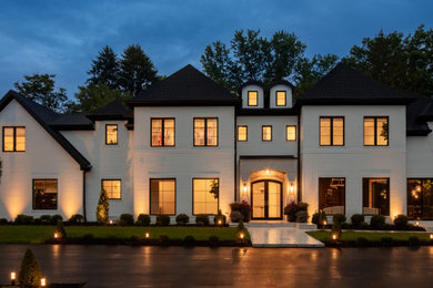 Example of a huge transitional white two-story brick house exterior design in Other with a hip roof, a shingle roof and a gray roof