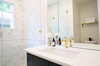 Traditional bathroom in Austin with flat-panel cabinets, black cabinets, a two-piece toilet, white tile, stone tile, white walls, marble floors, an undermount sink and engineered quartz benchtops.