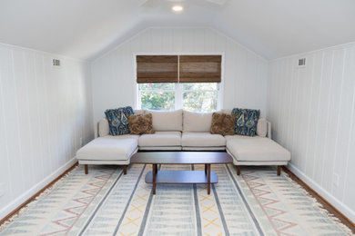 Family room - mid-sized modern medium tone wood floor, brown floor, vaulted ceiling and wall paneling family room idea in Atlanta with white walls