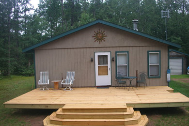 Example of a large minimalist backyard deck design in Other with no cover