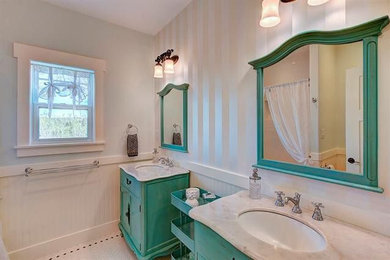 French country porcelain tile and wainscoting bathroom photo in Austin with turquoise cabinets, a one-piece toilet, an undermount sink, marble countertops, white countertops and a freestanding vanity
