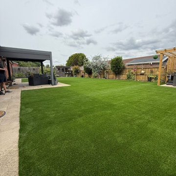 Artificial Lawn Curving Round to a Covered Seating Area