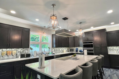 Inspiration for a mid-sized modern l-shaped ceramic tile and multicolored floor eat-in kitchen remodel in New York with an undermount sink, shaker cabinets, brown cabinets, quartz countertops, green backsplash, stone tile backsplash, stainless steel appliances, an island and multicolored countertops