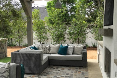 Example of a mid-sized beach style backyard stone patio design in Orange County with an awning