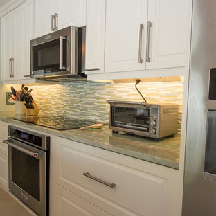 Idéer för ett modernt grön skafferi, med en enkel diskho, luckor med upphöjd panel, vita skåp, bänkskiva i kvartsit, stänkskydd i glaskakel, rostfria vitvaror, klinkergolv i porslin och en köksö