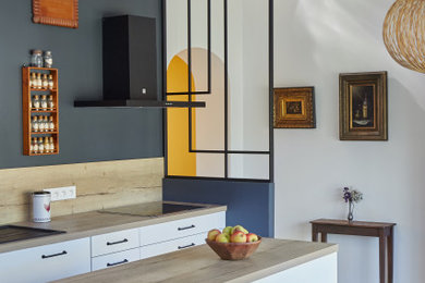 ナントにある高級な中くらいなトランジショナルスタイルのおしゃれなキッチン (ドロップインシンク、インセット扉のキャビネット、白いキャビネット、ラミネートカウンター、木材のキッチンパネル、淡色無垢フローリング) の写真