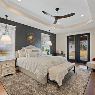 Imagen de dormitorio principal y machihembrado, de estilo de casa de campo, grande, machihembrado, con paredes beige, suelo de madera en tonos medios, suelo marrón y machihembrado
