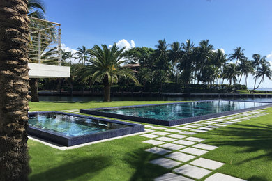 Expansive modern backyard rectangular lap pool in Miami with concrete pavers.