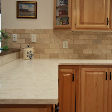 Travertine Backsplash and Quartz Countertops Add Freshness to Cabinets