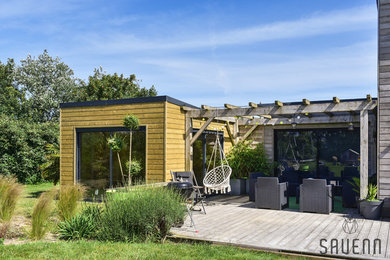 Modelo de patio contemporáneo de tamaño medio en patio trasero con entablado y pérgola
