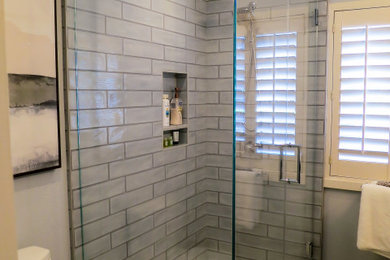 Example of a mid-sized transitional 3/4 blue tile and porcelain tile porcelain tile, beige floor and single-sink corner shower design in San Francisco with recessed-panel cabinets, dark wood cabinets, a one-piece toilet, blue walls, an undermount sink, quartz countertops, a hinged shower door, white countertops, a niche and a built-in vanity