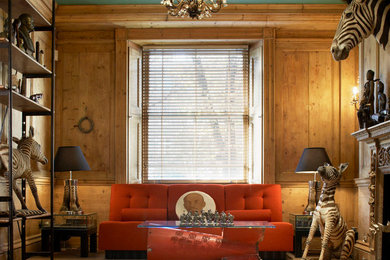 Eclectic medium tone wood floor living room photo in London with a standard fireplace