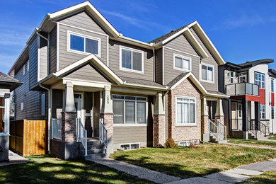 Inspiration for a mid-sized transitional beige two-story wood gable roof remodel in Calgary