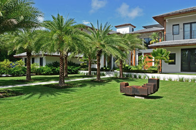 Design ideas for a large asian front yard full sun driveway in Miami with natural stone pavers.