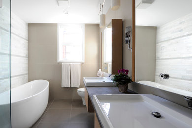 Inspiration for a large modern master porcelain tile bathroom remodel in Toronto with flat-panel cabinets, light wood cabinets, a one-piece toilet, beige walls and a vessel sink