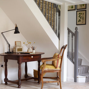 Small country study in Oxfordshire with white walls, limestone flooring, a freestanding desk, no fireplace and beige floors.