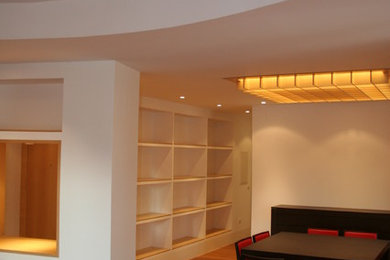 Imagen de salón abierto actual de tamaño medio sin chimenea con paredes blancas y suelo de madera en tonos medios