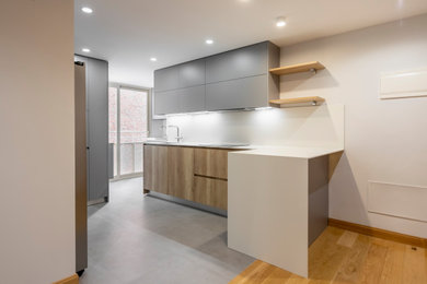 Foto de cocinas en L gris y blanca minimalista de tamaño medio abierta con fregadero bajoencimera, puertas de armario de madera clara, encimera de cuarzo compacto, salpicadero blanco, salpicadero de mármol, electrodomésticos de acero inoxidable, suelo de baldosas de porcelana, península, suelo gris y encimeras blancas
